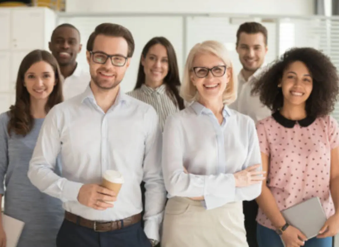Diverse group of smiling professionals in a casual office setting.