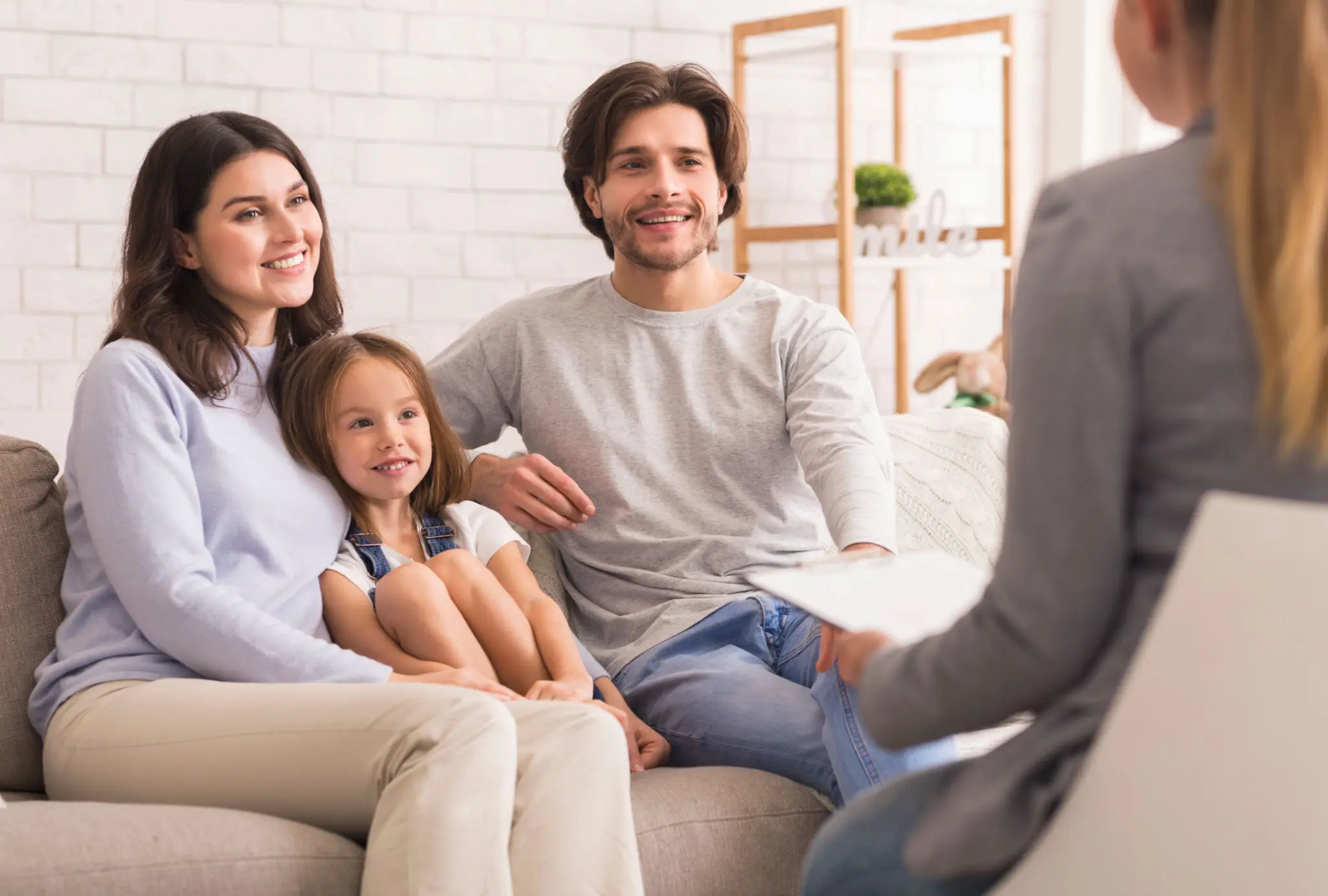 Happy family sitting on couch during a therapy session.