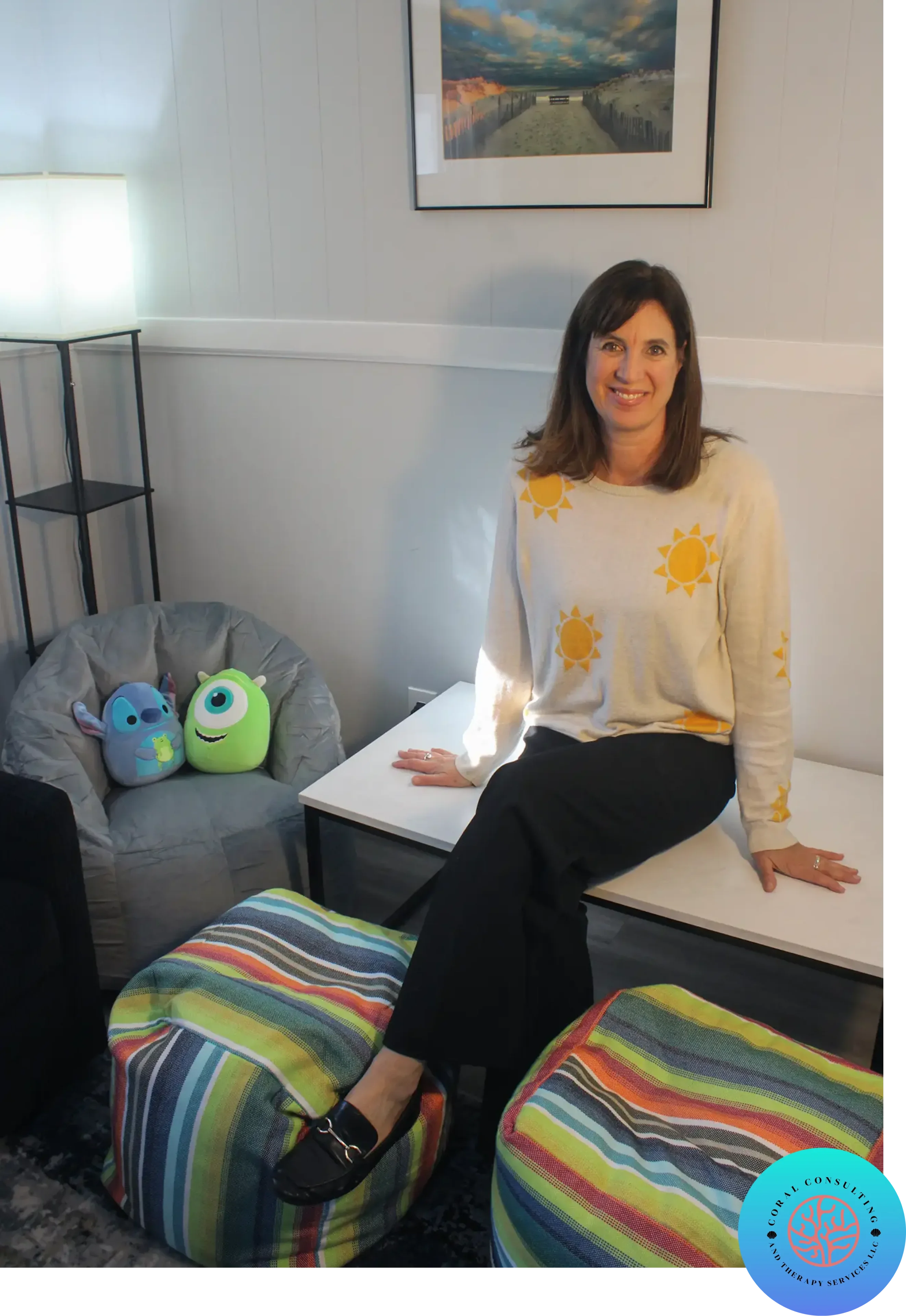 Woman sitting on a bench in a cozy room with colorful cushions.