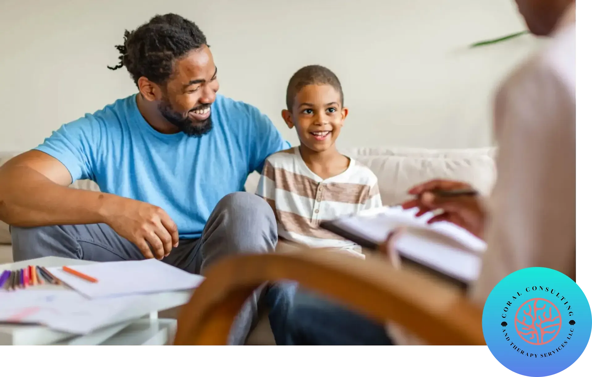 A father and son smiling during a discussion with a professional.