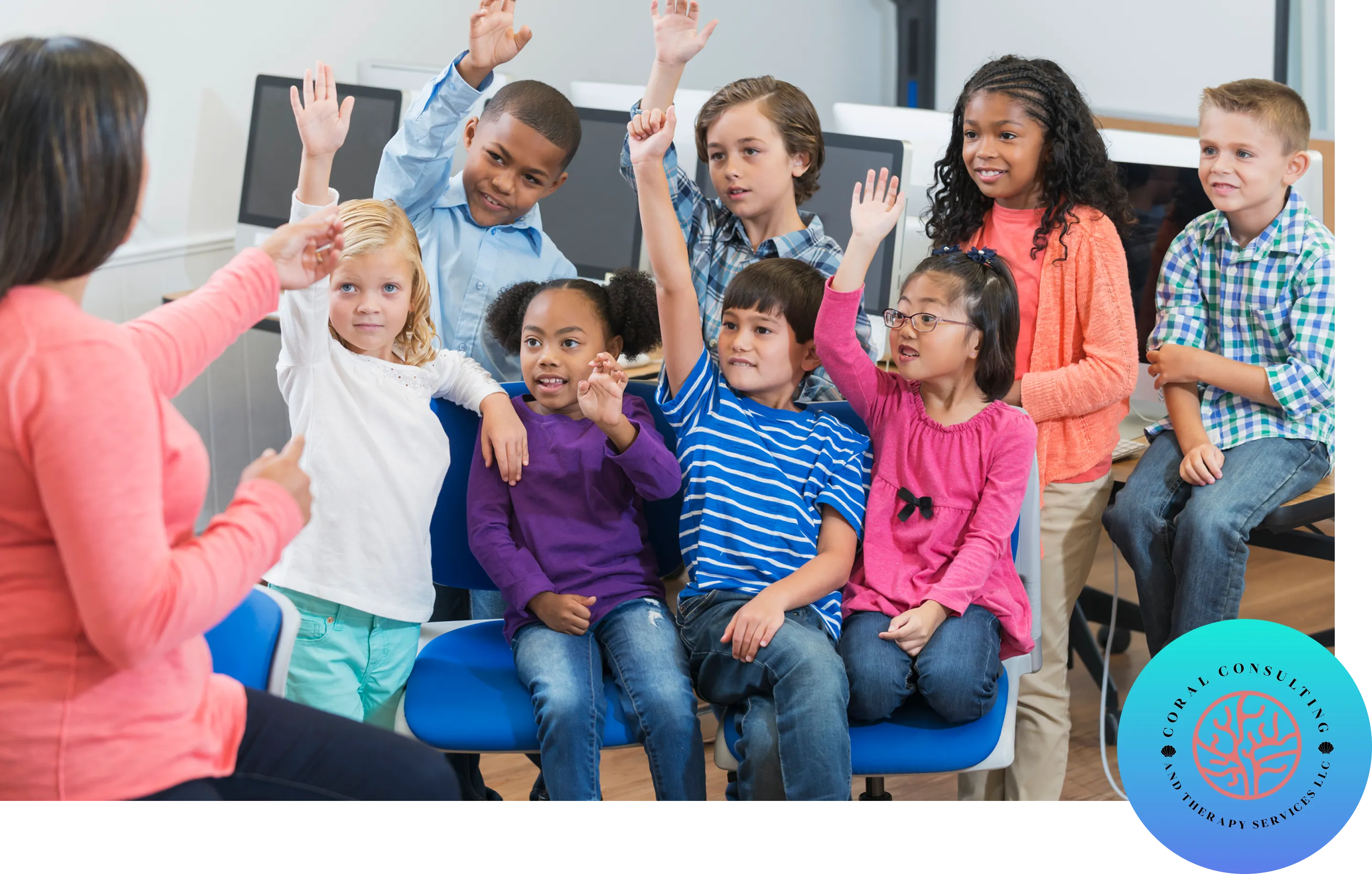 A group of children raising hands eagerly in a classroom.